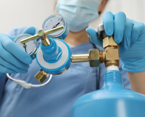 Medical Worker Checking Oxygen Tank In Hospital Room, Closeup